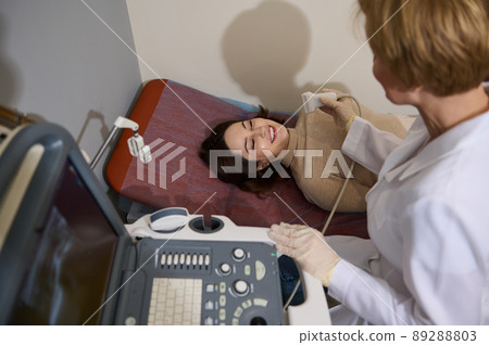 Doctor radiologist giving beautiful patient an ultrasound diagnostics for timely disease prevention, ultrasonography 89288803