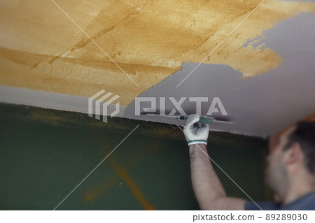 Selective focus. Plasterer applies plaster to the ceiling at repair renovation work. 89289030