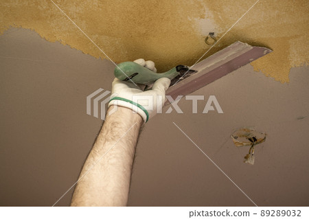 Plasterer applies plaster to the ceiling at repair renovation work. Plasterer applies plaster to the ceiling at repair renovation work. 89289032