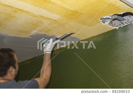 Selective focus. Plasterer applies plaster to the ceiling at repair renovation work. Selective focus. Plasterer applies plaster to the ceiling at repair renovation work. 89289033