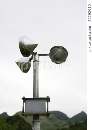 Anemometer pole on cloudy sky and mountain background 89292610