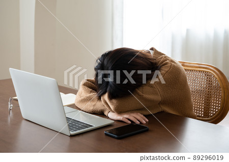 Asian woman lying face down on the table Asian woman lying face down on the table 89296019