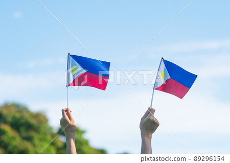 hand holding Philippines flag on nature background. 12th June of Independence day and happy celebration concepts hand holding Philippines flag on nature background. 12th June of Independence day and happy celebration concepts 89296154