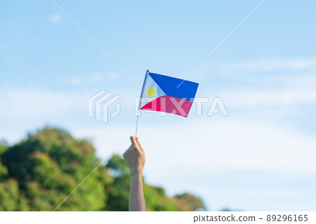 hand holding Philippines flag on nature background. 12th June of Independence day and happy celebration concepts hand holding Philippines flag on nature background. 12th June of Independence day and happy celebration concepts 89296165