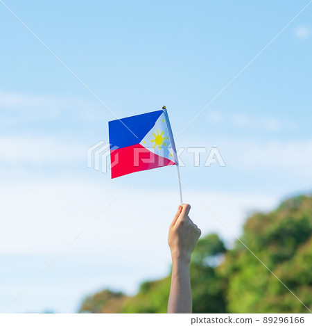 hand holding Philippines flag on nature background. 12th June of Independence day and happy celebration concepts hand holding Philippines flag on nature background. 12th June of Independence day and happy celebration concepts 89296166