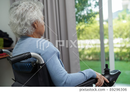 Asian elderly woman disability patient sitting on electric wheelchair in park, medical concept. Asian elderly woman disability patient sitting on electric wheelchair in park, medical concept. 89296306