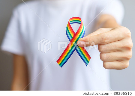 hand holding LGBTQ Rainbow ribbon for Support Lesbian, Gay, Bisexual, Transgender and Queer community and Pride month concept 89296510