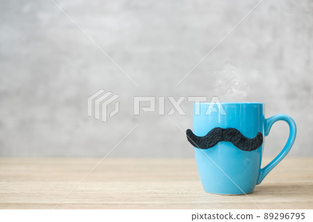 Blue coffee cup or tea mug with Black mustache decor on table. Blank copy space for text. Blue November, Happy Father day and International men day concept 89296795