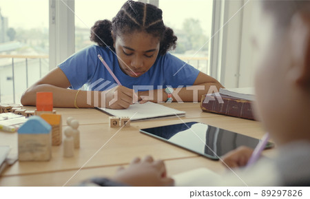 Student in international preschool writing a book together in Elementary School Class, Pupils enjoying studying in classroom. 89297826