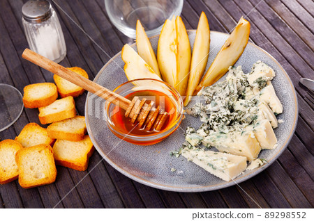 Roncari blue cheese served on plate with pear, croutons and honey Roncari blue cheese served on plate with pear, croutons and honey 89298552