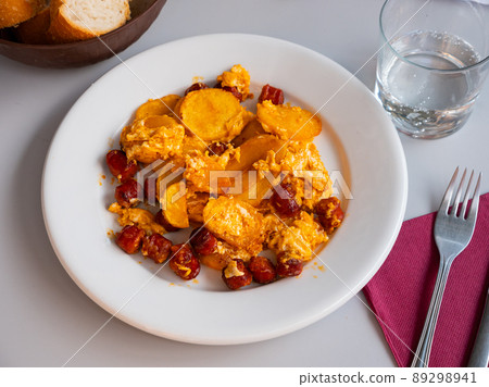 Huevos con chistorra. Scrambled eggs with sausage and potatoes Huevos con chistorra. Scrambled eggs with sausage and potatoes 89298941