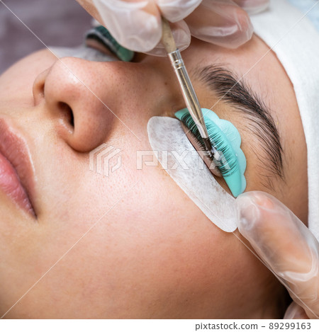 Close-up portrait of a woman on eyelash lamination procedure.  89299163