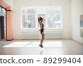 Cute young girl jumping rope in gym, warm up before training 89299404