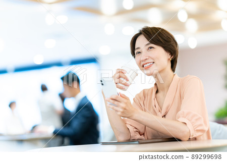 A woman watching a smartphone A woman watching a smartphone 89299698