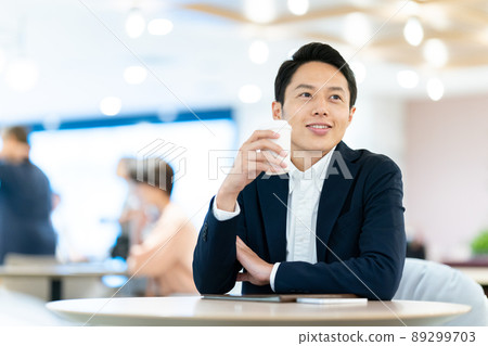 Businessman drinking coffee in the office Businessman drinking coffee in the office 89299703
