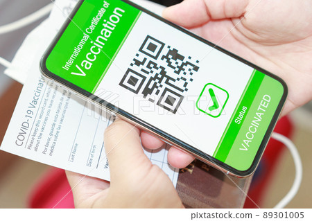 Tourists presenting passports and digital health certificates on their mobile phones. Covid-19 vaccinated travel concept. 89301005