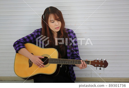 Girl singing on microphone and playing guitar Girl singing on microphone and playing guitar 89301736