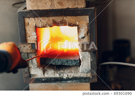 Blacksmith forge oven with hot flame. Smith heating iron piece of steel in fire of red-hot forge. Blacksmith forge oven with hot flame. Smith heating iron piece of steel in fire of red-hot forge. 89301890