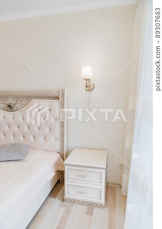 a large classic bed with a soft headboard and covering bedside table . a large classic bed with a soft headboard and covering bedside table . 89307683