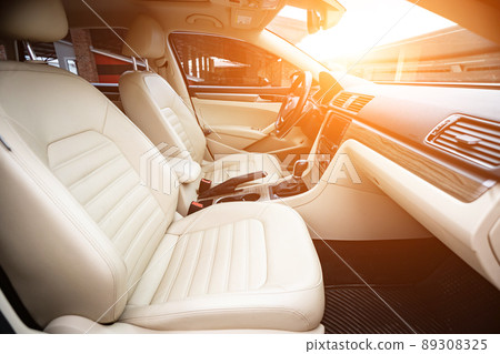 Car interior luxury. Beige comfortable seats, steering wheel, dashboard, climate control, speedometer, display, wood decoration light Car interior luxury. Beige comfortable seats, steering wheel, dashboard, climate control, speedometer, display, wood decoration light 89308325