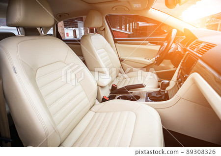 Car interior luxury. Beige comfortable seats, steering wheel, dashboard, climate control, speedometer, display, wood decoration light Car interior luxury. Beige comfortable seats, steering wheel, dashboard, climate control, speedometer, display, wood decoration light 89308326