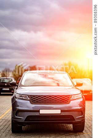 Predatory car headlight with blue lights and hood of powerful grey blue car sports car with matte grey paint and wheel with blue disc 89308396
