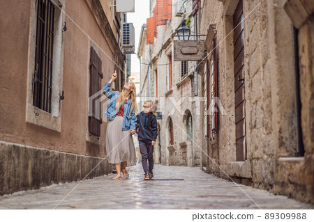 Mom and son travelers enjoying Colorful street in Old town of Kotor on a sunny day, Montenegro. Travel to Montenegro concept 89309988