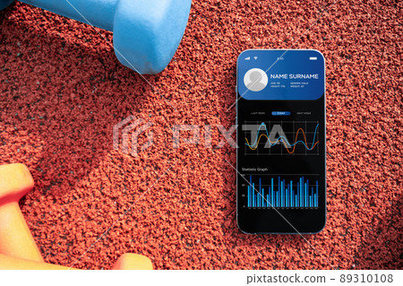 Gym app. Smartphone screen with sport gym or fitness health mobile application on dumbbell background. App for training indoors. 89310108