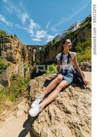 Tourist girl on the background of the famous bridge in Ronda, Spain 89311059