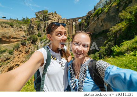 Tourist girl on the background of the famous bridge in Ronda, Spain 89311125