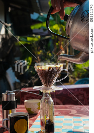Drip brewing coffee by paper filtered on table morning outdoor Drip brewing coffee by paper filtered on table morning outdoor 89311176
