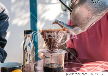 Drip brewing coffee by paper filtered on table morning outdoor Drip brewing coffee by paper filtered on table morning outdoor 89311178