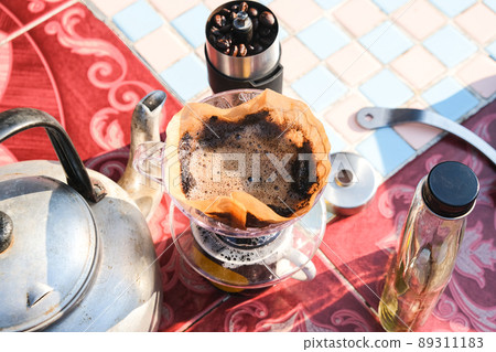 Drip brewing coffee by paper filtered on table morning outdoor 89311183