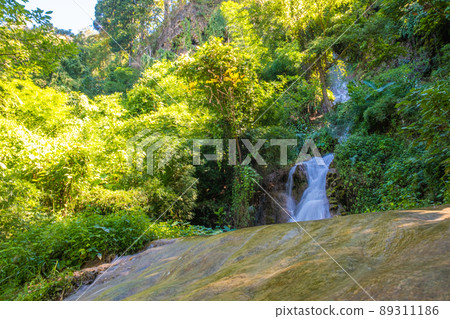 Amazing waterfall in tropical forest sun light on green tree nature landscape 89311186