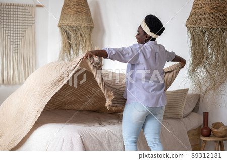 African woman in a bedroom with ethnic interior African woman in a bedroom with ethnic interior 89312181