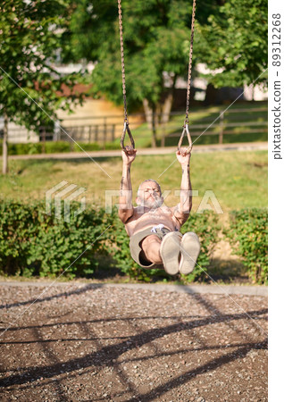 A mature gray-haired man exercising in the park A mature gray-haired man exercising in the park 89312268