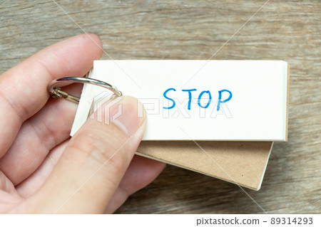 Man hold the flash card with handwriting word stop on wood background Man hold the flash card with handwriting word stop on wood background 89314293