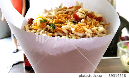 Bhel poori, an Indian road side snack in a conical shape paper container 89314838