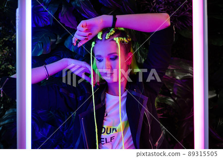 Millennial young woman with yellow hair in trendy neon pink and blue lights.  89315505