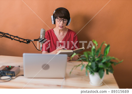 Middle-aged woman radio host making podcast recording for online show - broadcast and dj concept 89315689