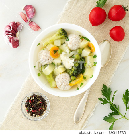 bowl of soup, a cup of broth and vegetables, meatballs made of turkey and chicken, top view 89315783