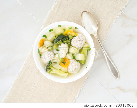 bowl of soup, a cup of broth and vegetables, meatballs made of turkey and chicken, top view 89315803