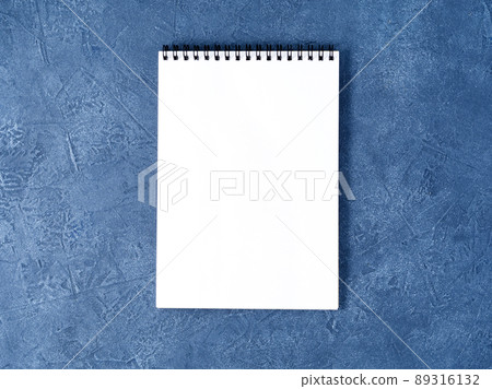 The open notepad with clean white page on aged dark blue stone table, top view 89316132