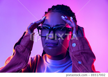 Portrait of female fashion model in cotton shirt isolated on purple background in neon light. Concept of beauty, art, fashion, youth and emotions 89317002