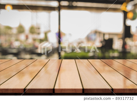 Empty wooden table top with lights bokeh on blur restaurant background. Empty wooden table top with lights bokeh on blur restaurant background. 89317732