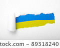 Ukrainian blue and yellow flag in the hole in paper 89318240