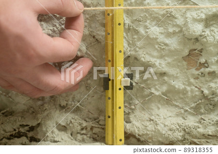 Metal guides for plastering walls, installation of metal beacons on the wall. Metal guides for plastering walls, installation of metal beacons on the wall. 89318355