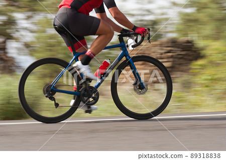 Road bike cyclist man cycling, athlete on a race cycle. Panning technique used 89318838