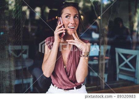 Joyful middle aged lady calling on smartphone on street 89320983