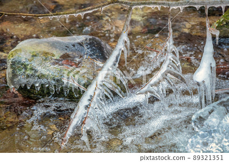 Winter landscape of a wild stream with ice formations . 89321351